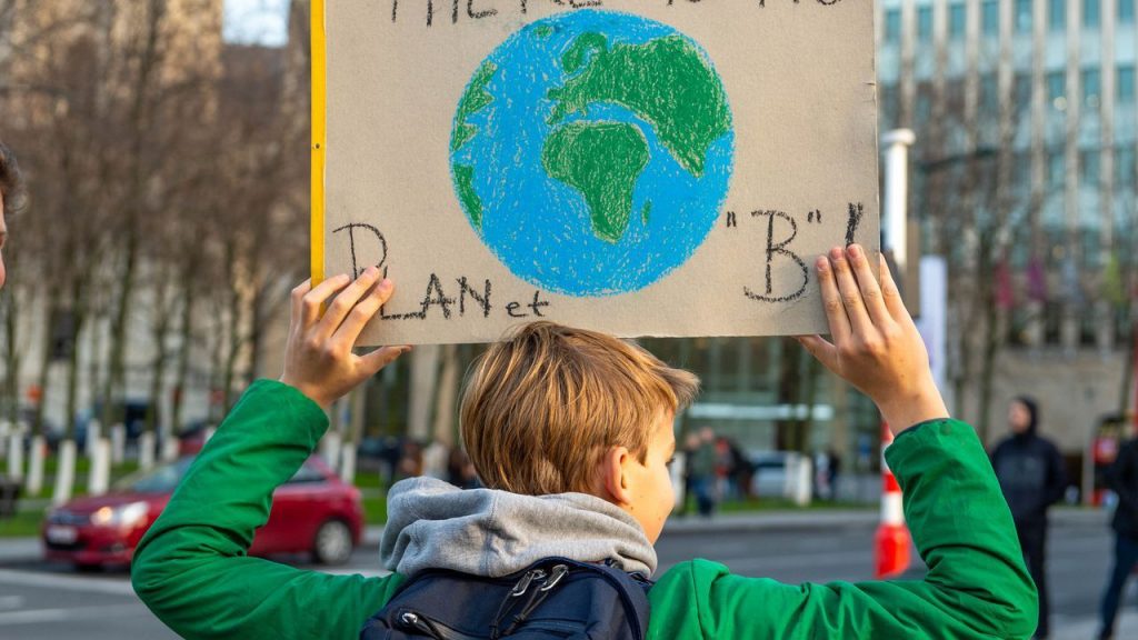 Kid holding a sign about the planet